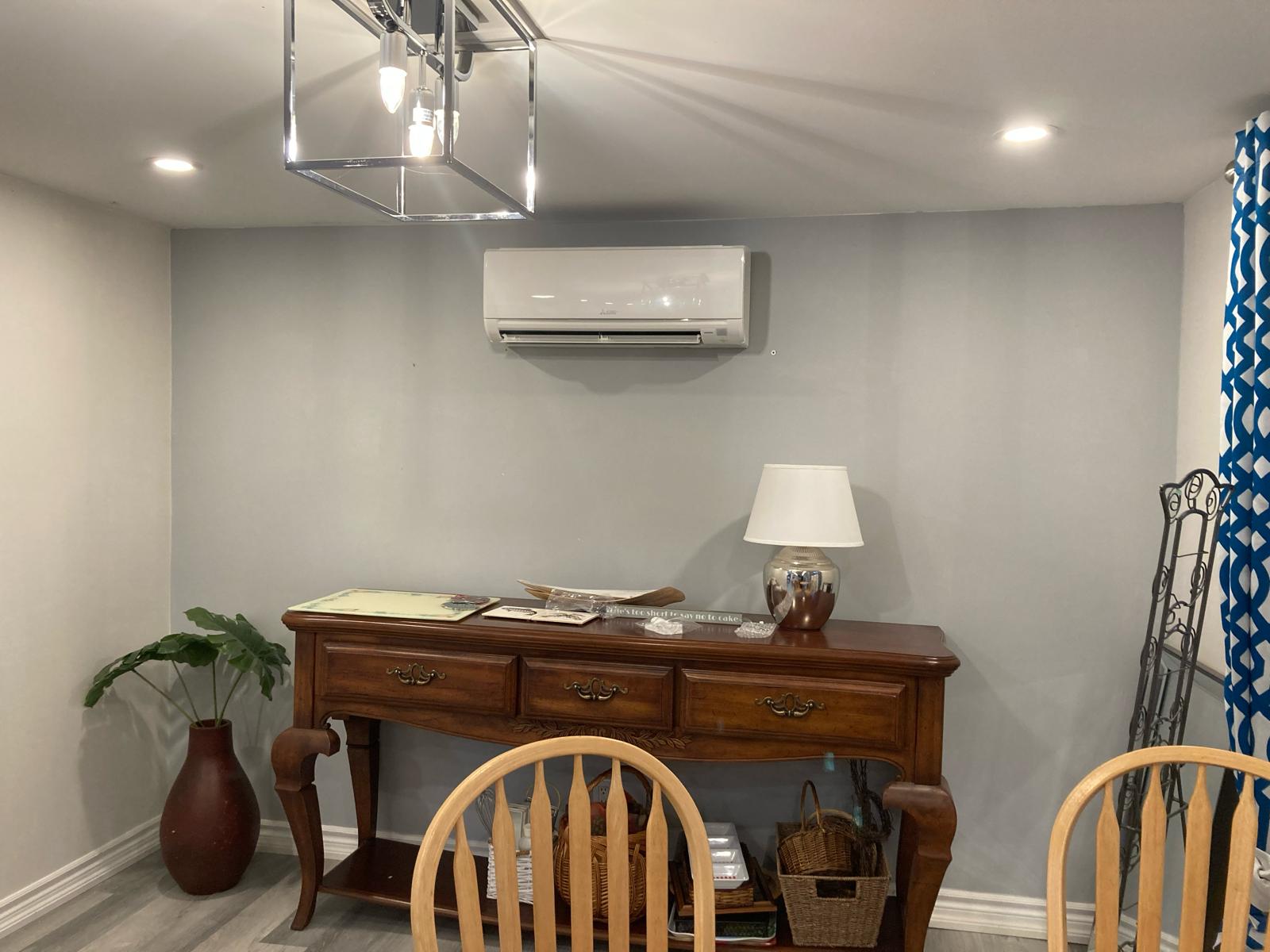 Modern Mitsubishi ductless mini-split indoor unit installed in a dining room for quiet, zoned cooling and heating.